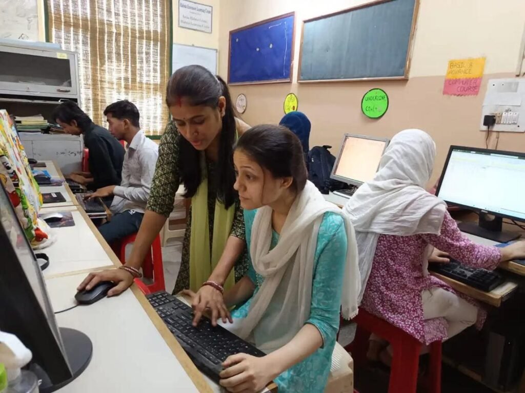Computer instructor guiding a beginner during a practical training session